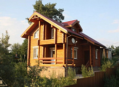 Двухэтажный дом из бревна с террасой и балконом 0